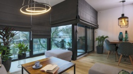 Uniwersalne szarości – aranżacja pokoju dziennego z roletami rzymskimi